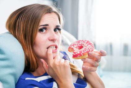 Woman on diet caught during eating unhealthy donut